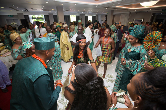 Guests dancing on money-covered dancefloor